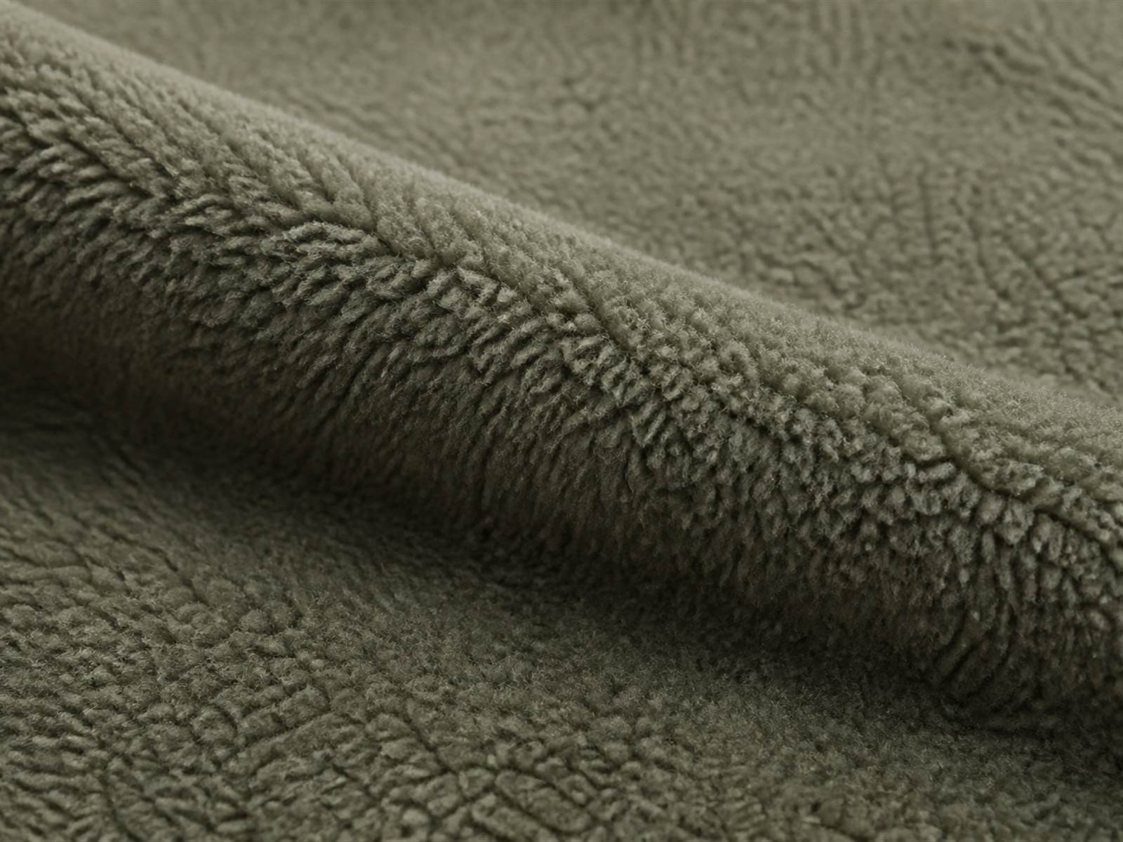 Macro view of fleece fabric showing raised pile structure used for tactical cold weather mid layers