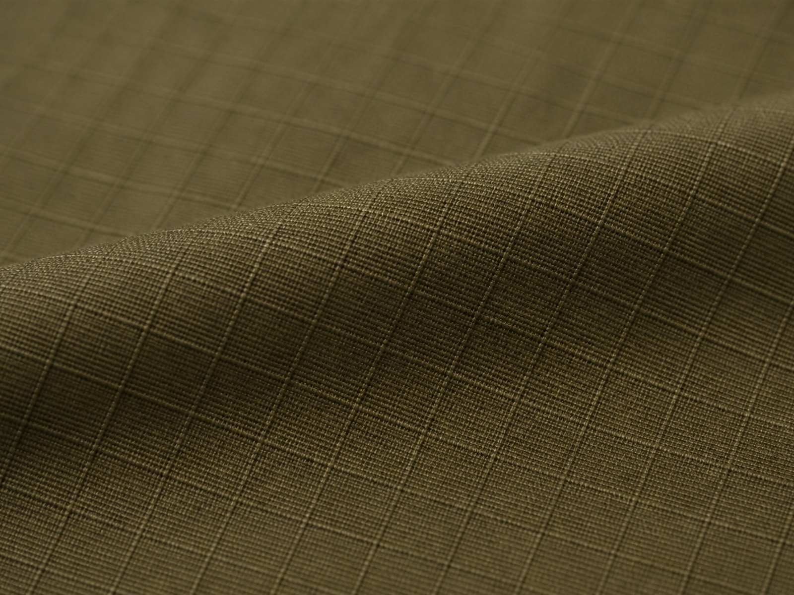 Macro view of poly cotton ripstop fabric showing the reinforcing grid used in tactical clothing